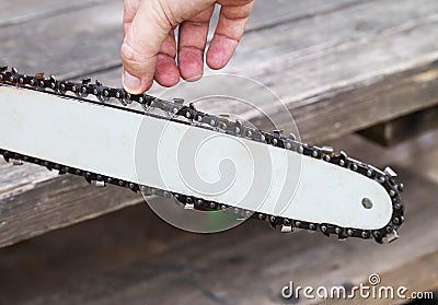 Correct chain tension using the special tool on the chainsaw bar. Chain tension adjustment Stock Photo