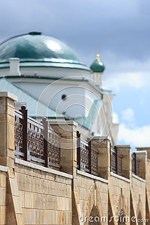 Old church with turquoise dome behind contemporary fence Stock Photo