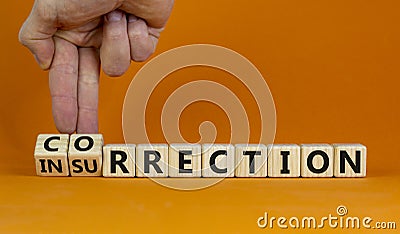 Businessman turns wooden cubes and changes word insurrection to correction. Beautiful orange Stock Photo