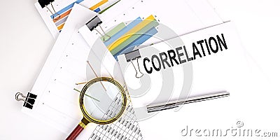 CORRELATION , text on white paper on the light background with charts paper Stock Photo