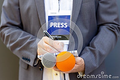 Correspondent or journalist at media event, holding microphone, writing notes. Journalism concept. Stock Photo