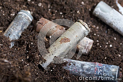 A corroded battery is lying on the ground. Environmental protection and waste recycling. Close-up shot Stock Photo