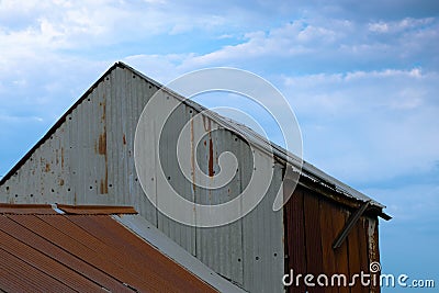 Corrugated iron farm building with red roof Stock Photo