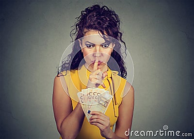 Corrupt, secretive woman with euro money showing shhh sign Stock Photo