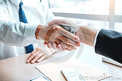 Corruption and Bribery ,Businessman shaking hands giving dollar bills corruption bribery to business manager to deal contract Stock Photo
