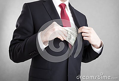 Corruption. Man putting money in suit jacket pocket. Stock Photo