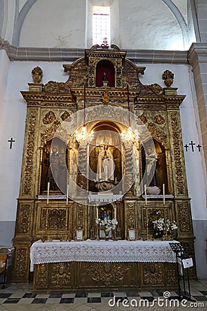 Vertical view. Ornate side altar of Divino Salvador church in the Andalusian magical town of Cortegana, Huelva, Spain Editorial Stock Photo