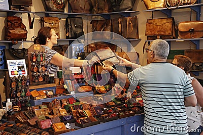 Tourist couple buying a leather wallet at a craft fair Editorial Stock Photo