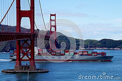 Cosco cargo ship passes beneath the Golden Gate bridge in San Fransisco Editorial Stock Photo