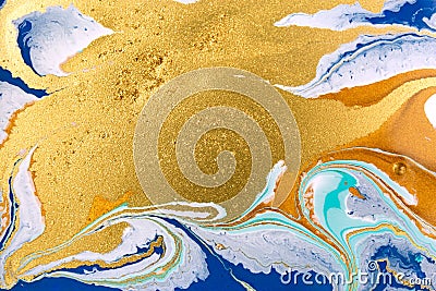 Cose up gold glitter wave on liquid blue and white paint background. Stock Photo
