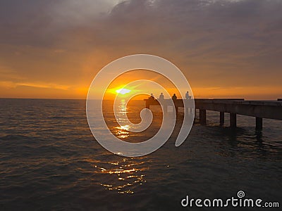 Closeup view peaceful beach with unidentified people during sunset. Stock Photo