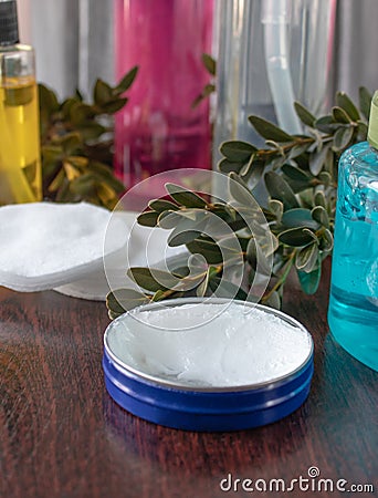 Cosmetic accessories on a dark background, white cream in a blue jar Stock Photo