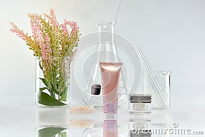 Cosmetic bottle containers with green herbal leaves and scientific glassware, Blank label package for branding mock-up. Stock Photo