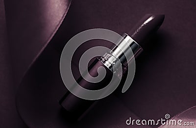 Luxury lipstick and silk ribbon on dark purple holiday background, make-up and cosmetics flatlay for beauty brand product design Stock Photo