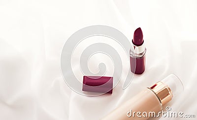 Beige tonal cream bottle make-up fluid foundation base and dark lipstick on silk background, cosmetics products as luxury beauty Stock Photo