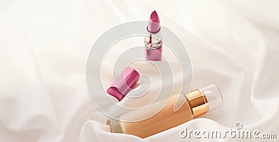 Beige tonal cream bottle make-up fluid foundation base and pink lipstick on silk background, cosmetics products as luxury beauty Stock Photo