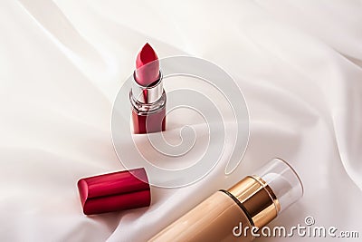 Beige tonal cream bottle make-up fluid foundation base and red lipstick on silk background, cosmetics products as luxury beauty Stock Photo