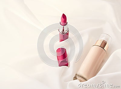 Beige tonal cream bottle make-up fluid foundation base and red lipstick on silk background, cosmetics products as luxury beauty Stock Photo