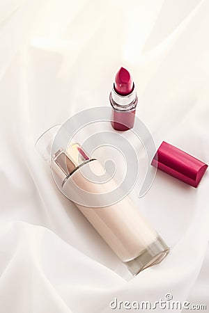 Beige tonal cream bottle make-up fluid foundation base and red lipstick on silk background, cosmetics products as luxury beauty Stock Photo