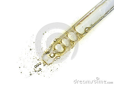 Cosmetic liquid dropper with clear yellow oil serum in pipette with bubbles isolated on white Stock Photo