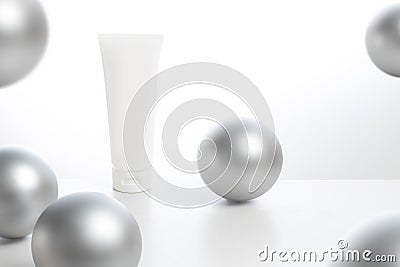 cosmetic lotion beauty cream facial mockup package tube with silver gloss ball decoration on white background in spa healty treatm Stock Photo