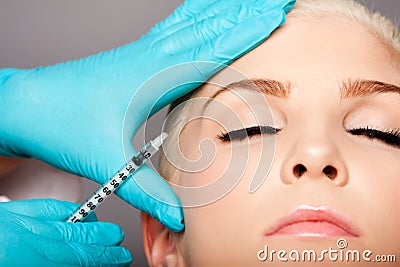 Cosmetic plastic surgeon injecting aesthetics face Stock Photo