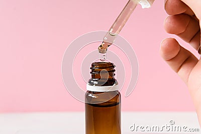 cosmetic product, bottle with hyaluronic acid on a pink background, close-up. Copy space Stock Photo