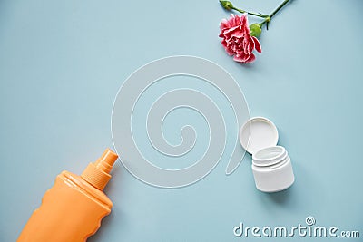 Cosmetic products mock up with decorative flowers. Feminine concept with copy space. Stock Photo