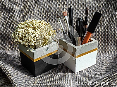 Cosmetic set and dried flower in cubic shape concrete container Stock Photo