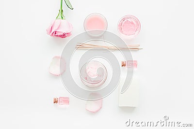 Cosmetic set with rose blossom and body cream on white desk background top view Stock Photo