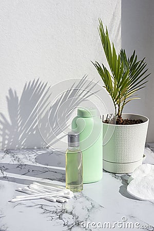 Cosmetic skincare products on marble background with palm leaves shadow. Glass bottle of natural oil, modern concept of organic Stock Photo
