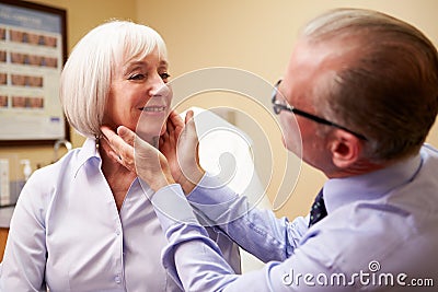 Cosmetic Surgeon Examining Senior Female Client In Stock Photo