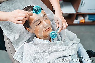 Cosmetician massaging the woman face with ice cubes Stock Photo