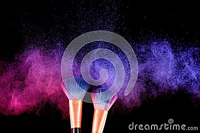 Cosmetics brush and explosion colorful makeup powder Stock Photo