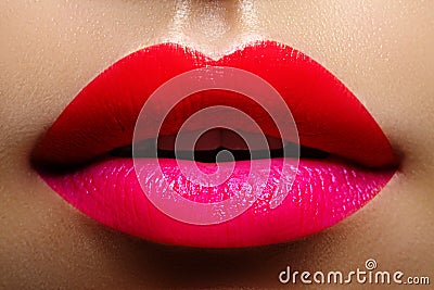 Cosmetics, makeup. Bright lipstick on lips. Closeup of beautiful female mouth with red and pink lip makeup. Part of face Stock Photo