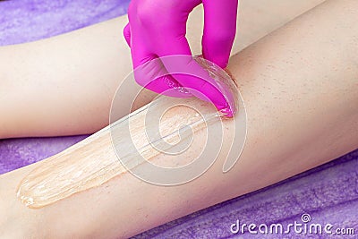 Cosmetologist beautician waxing female legs in a beauty salon Stock Photo