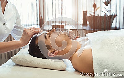 Cosmetologist cleaning man face with two sponges Stock Photo