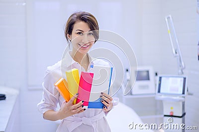A cosmetologist dermatologist holds in his hands a package with drugs for facial rejuvenation. A female doctor in his Stock Photo