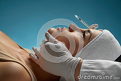 Cosmetologist holding syring enear lying patient. Stock Photo