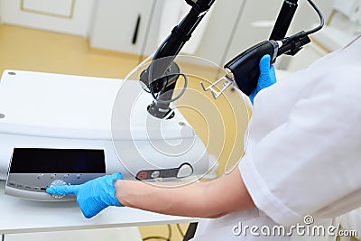 cosmetologist holds a CO2 fractional ablative laser for skin rejuvenation and scar removal in his hands and prepares for Stock Photo