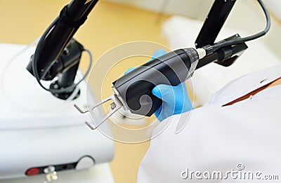 cosmetologist holds a CO2 fractional ablative laser for skin rejuvenation and scar removal in his hands and prepares for Stock Photo