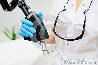 cosmetologist holds a CO2 fractional ablative laser for skin rejuvenation and scar removal in his hands and prepares for Stock Photo