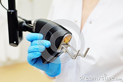 cosmetologist holds a CO2 fractional ablative laser for skin rejuvenation and scar removal in his hands and prepares for Stock Photo