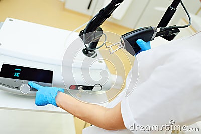 cosmetologist holds a CO2 fractional ablative laser for skin rejuvenation and scar removal in his hands and prepares for Stock Photo