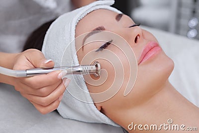 The cosmetologist makes the procedure Microdermabrasion of the facial skin Stock Photo