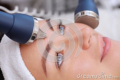 The cosmetologist makes the procedure an ultrasonic cleaning of the facial skin Stock Photo