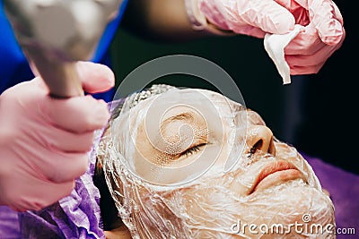 Cosmetologist performs laser rejuvenation procedure. CO2 Fractional Laser Stock Photo