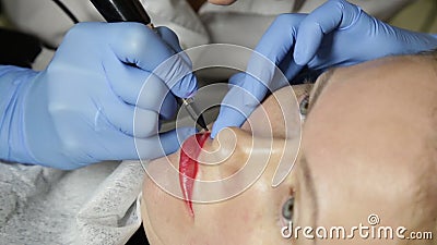 Cosmetologist que aplica maquillaje permanente Mujer hermosa joven que tiene tatuaje cosmético en sus labios Balneario sano almacen de video Cosmetologist que aplica maquillaje permanente Mujer hermosa joven que tiene tatuaje cosmético en sus labios Balneario sano almacen de video