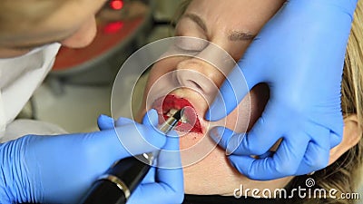 Cosmetologist que aplica maquillaje permanente Mujer hermosa joven que tiene tatuaje cosmético en sus labios Balneario sano metrajes Cosmetologist que aplica maquillaje permanente Mujer hermosa joven que tiene tatuaje cosmético en sus labios Balneario sano metrajes