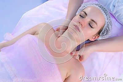 Cosmetologist`s hands making myoplastic lifting massage on woman`s neck. Stock Photo